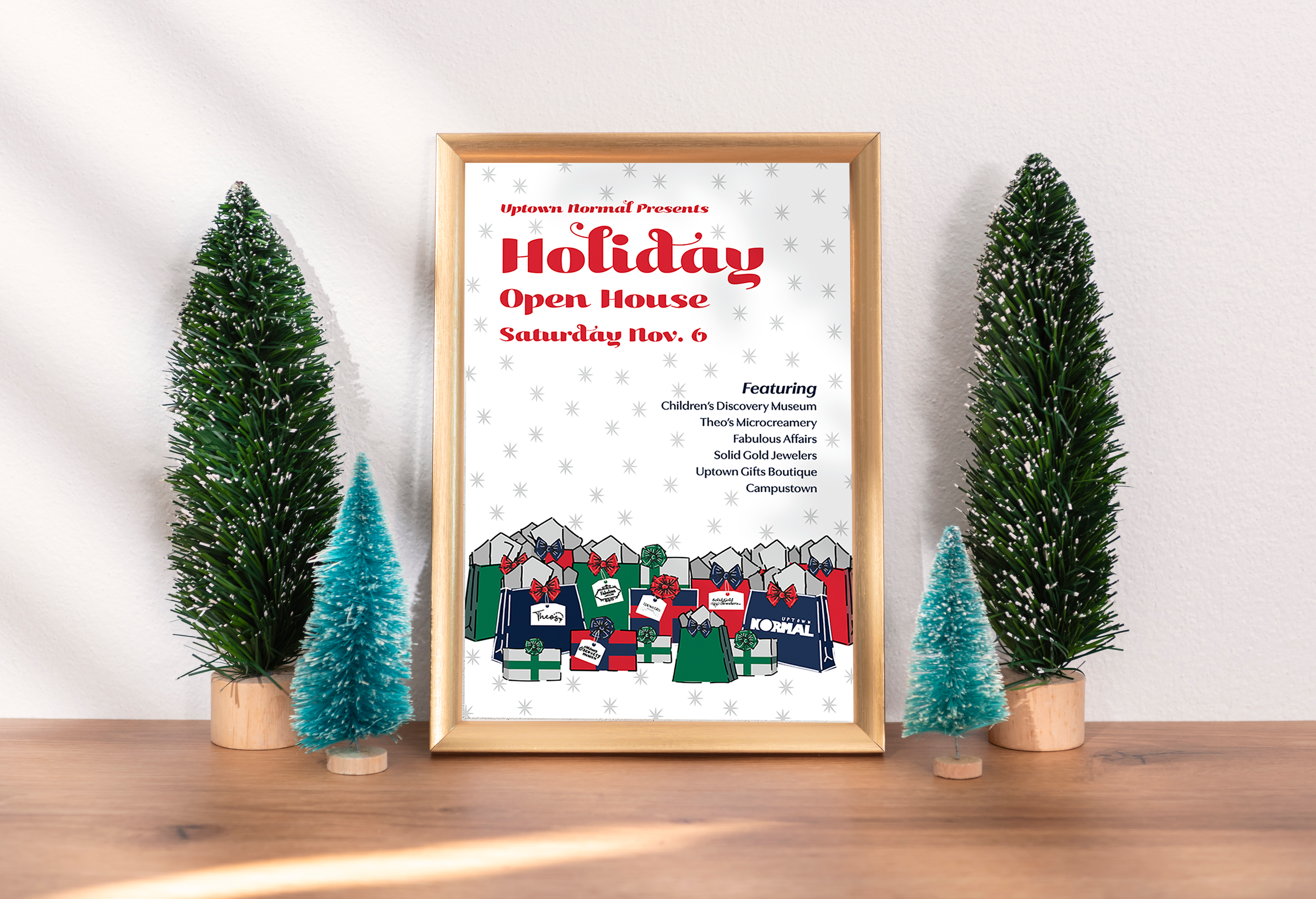 Holiday poster on a table surrounded by Christmas tree ornaments